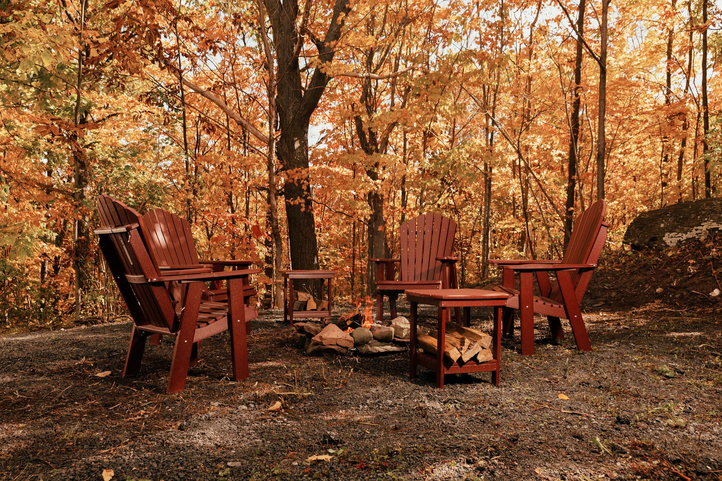 Adirondack chairs by a fire pit in autumn
